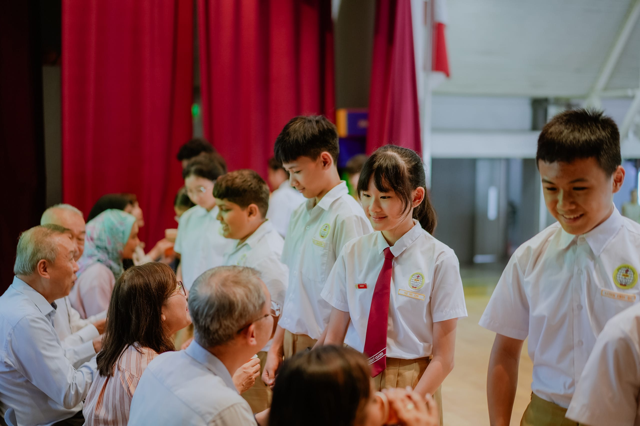 P6 student serving tea to GOH and student leader. 